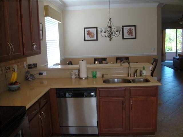 kitchen, slistone counter, stainless appliances overlooking dining room