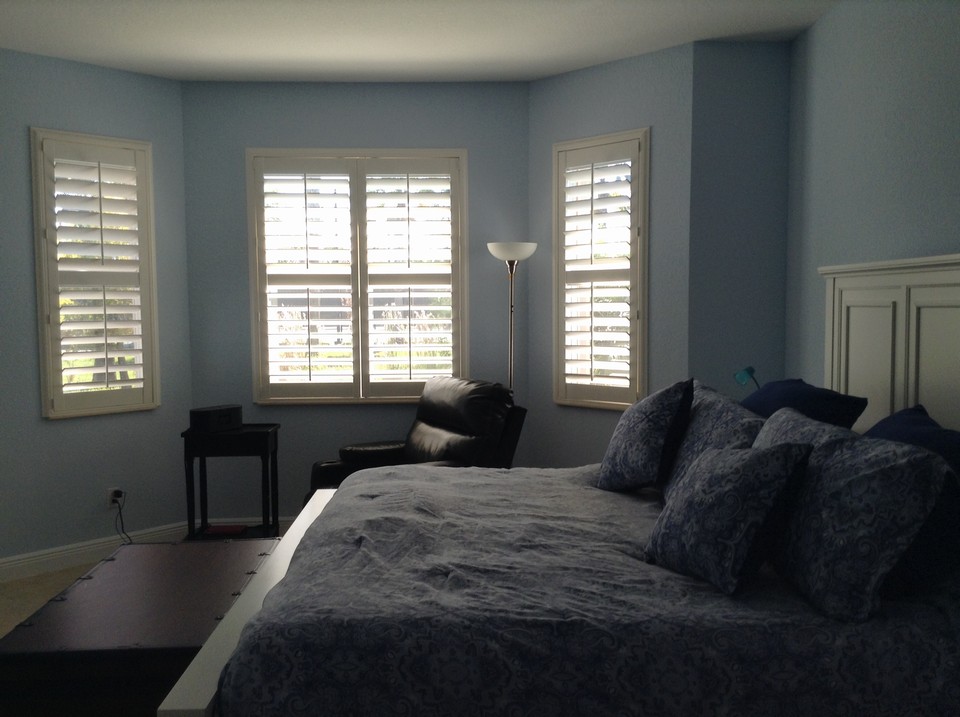 master bedroom with bay window and plantation shutters
