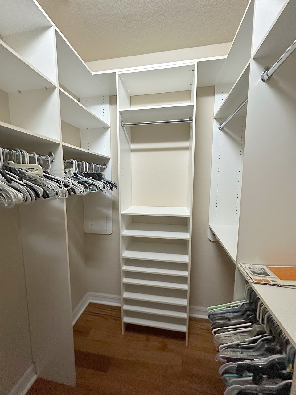primary bedroom walk in closet with built in shelving