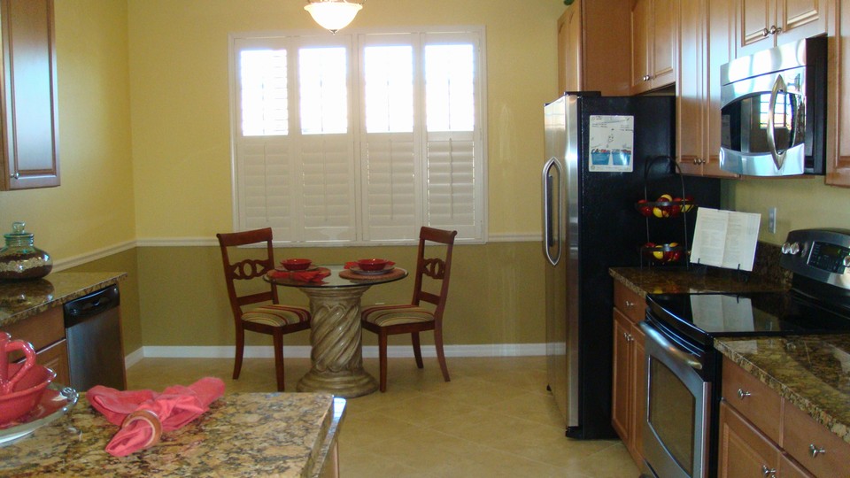 kitchen with breakfast table, plantation shutters, granite & stainless appliances