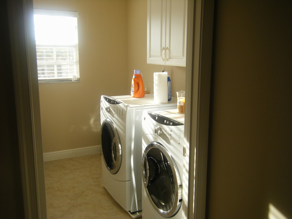 laundry room, storage cabinets and a sink