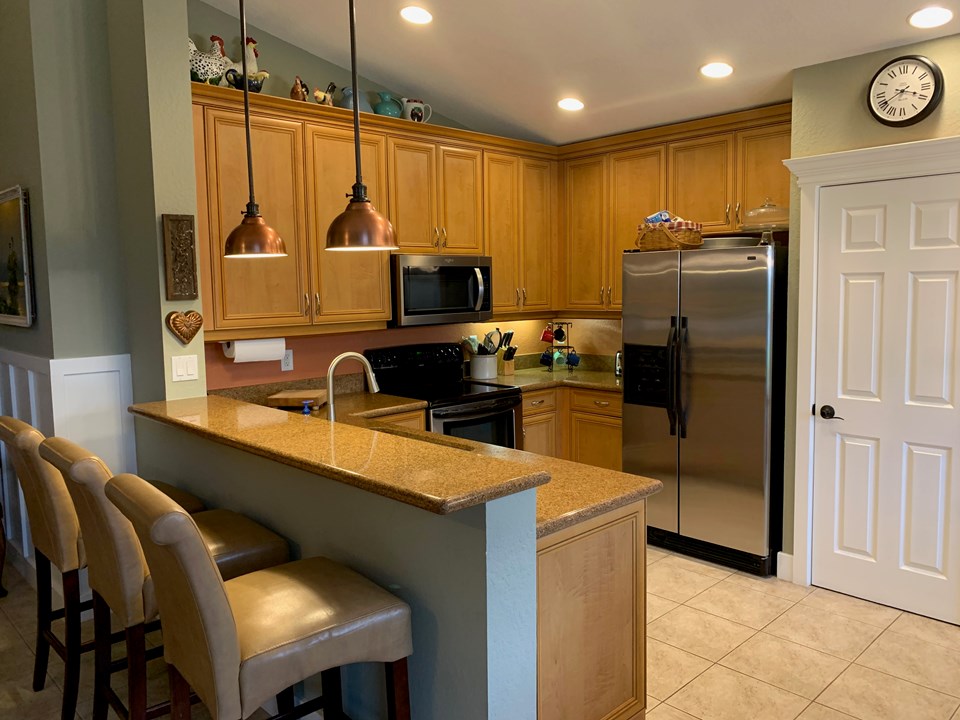granite snack counter in kitchen-ss appliances-under-mount lighting