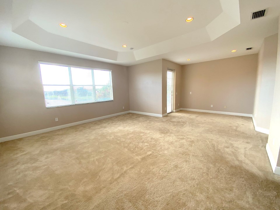 master suite, sitting area, tray ceiling and door to balcony