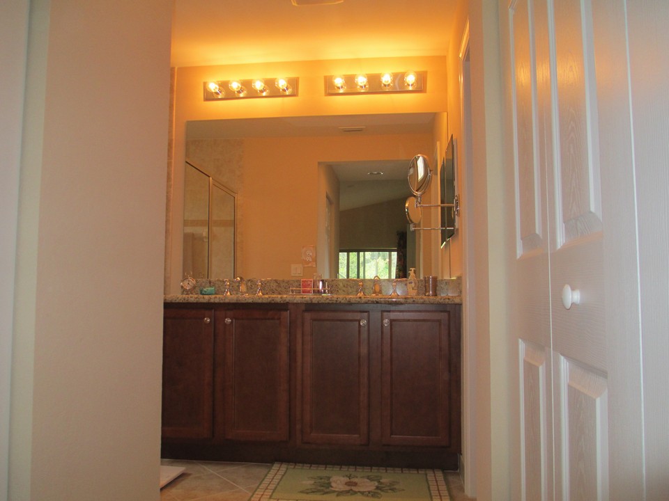 master bath with raised cabinets and granite counters