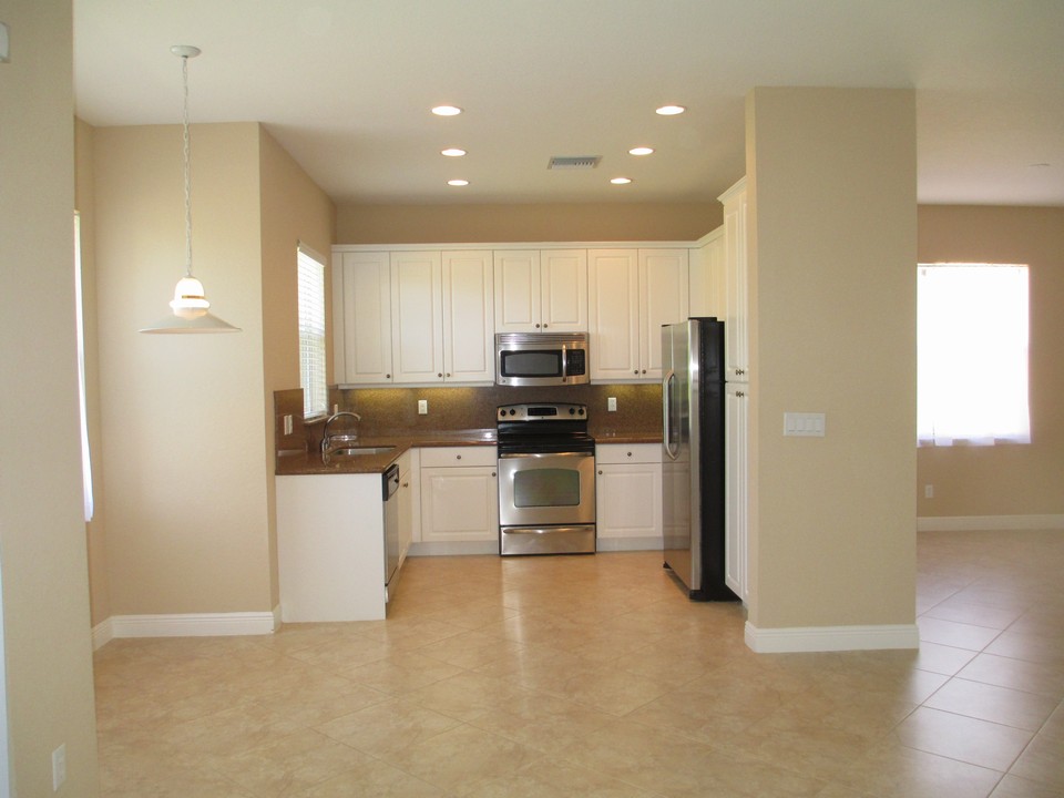 kitchen with ss appliances, granite counters & backsplash, undermount lights