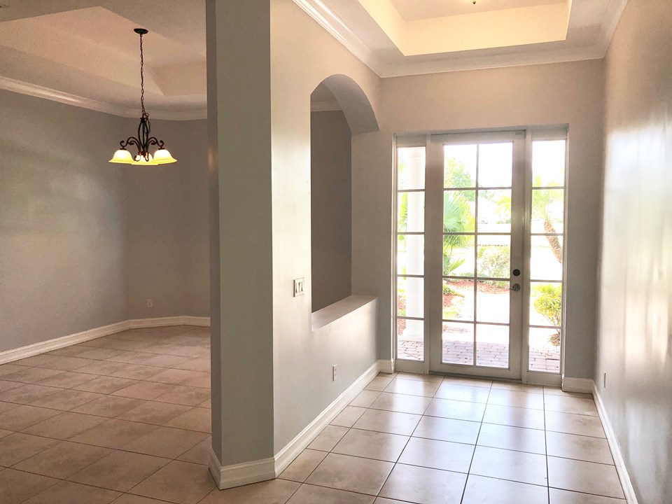 foyer with tray ceiling, crown molding