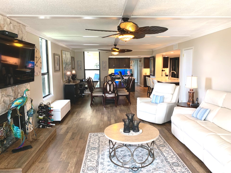 view from ocean balcony to living room with decorative stone fireplace